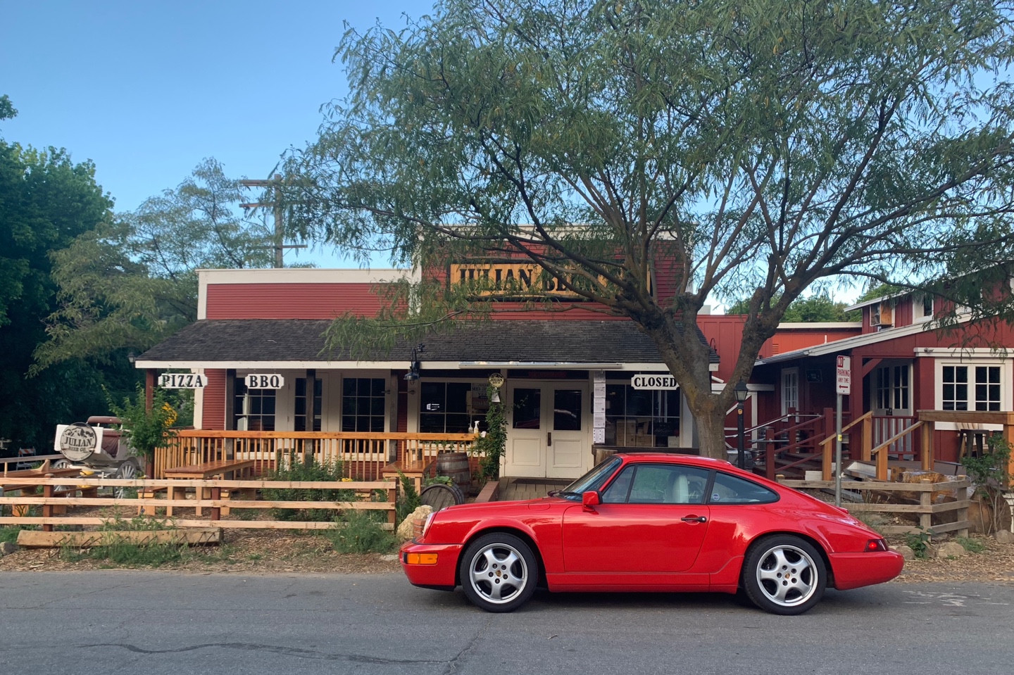 The 911 pauses in front of a wooden building.