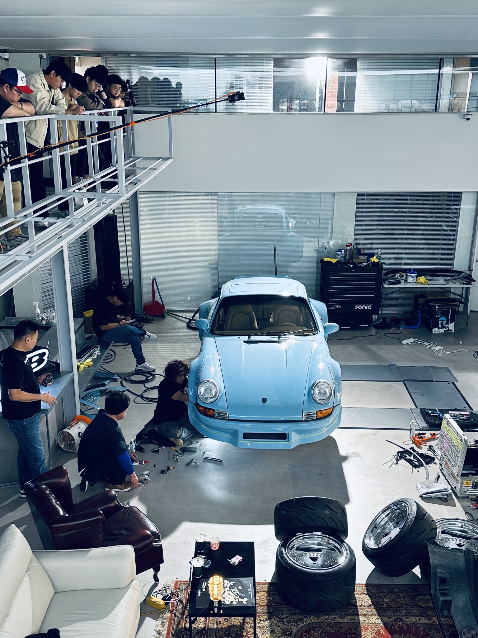 HANGANG Porsche 964 build surrounded by people recording the windscreen banner