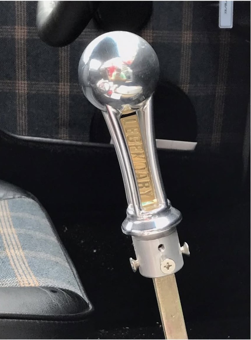 The owner-made manual gear lever with its gold-plated LEGENDARY logo.