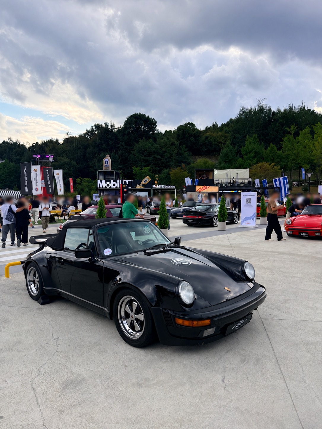 A black classic 911 in the outdoor display. Faces blurred for privacy.
